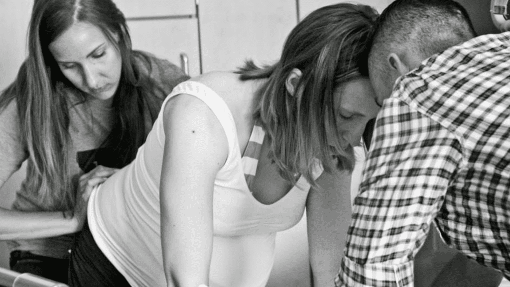 Portland doula helping a pregnant woman and her partner with relaxation techniques during labor.