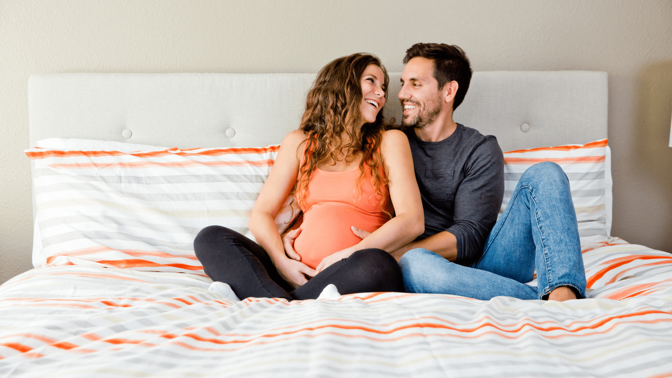 Bradley Method Classes | Image of Man holding Pregant Woman in Bed