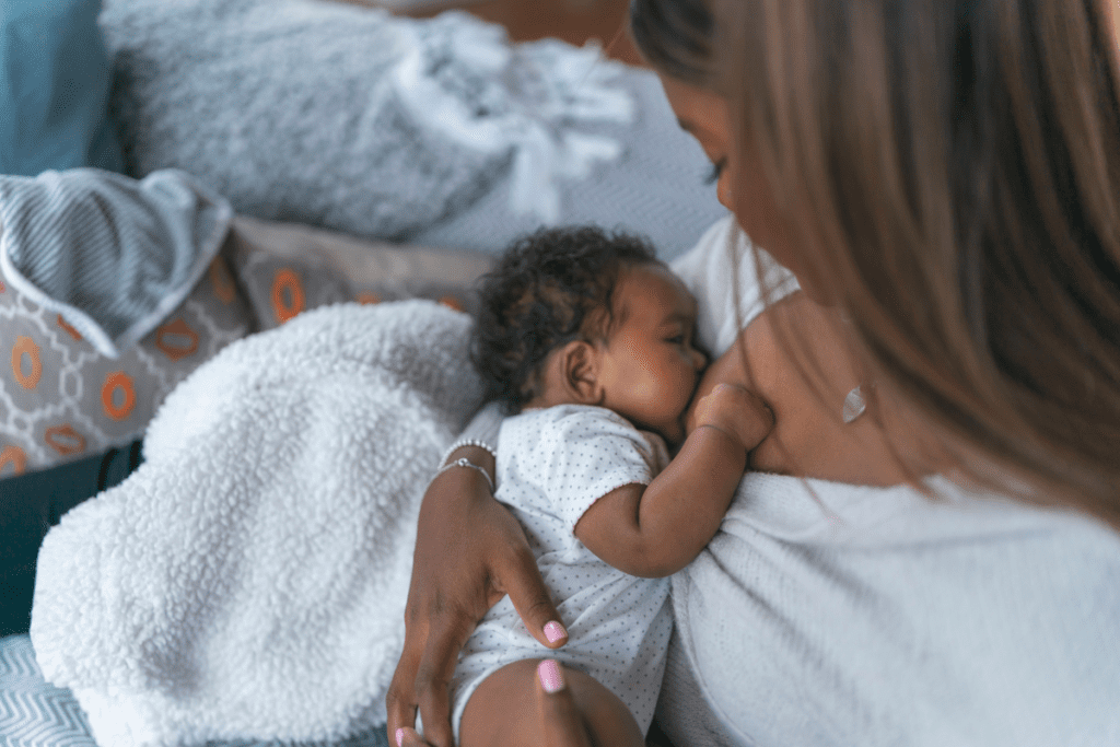 A mother cradling her newborn close to her chest and gently breastfeeding.