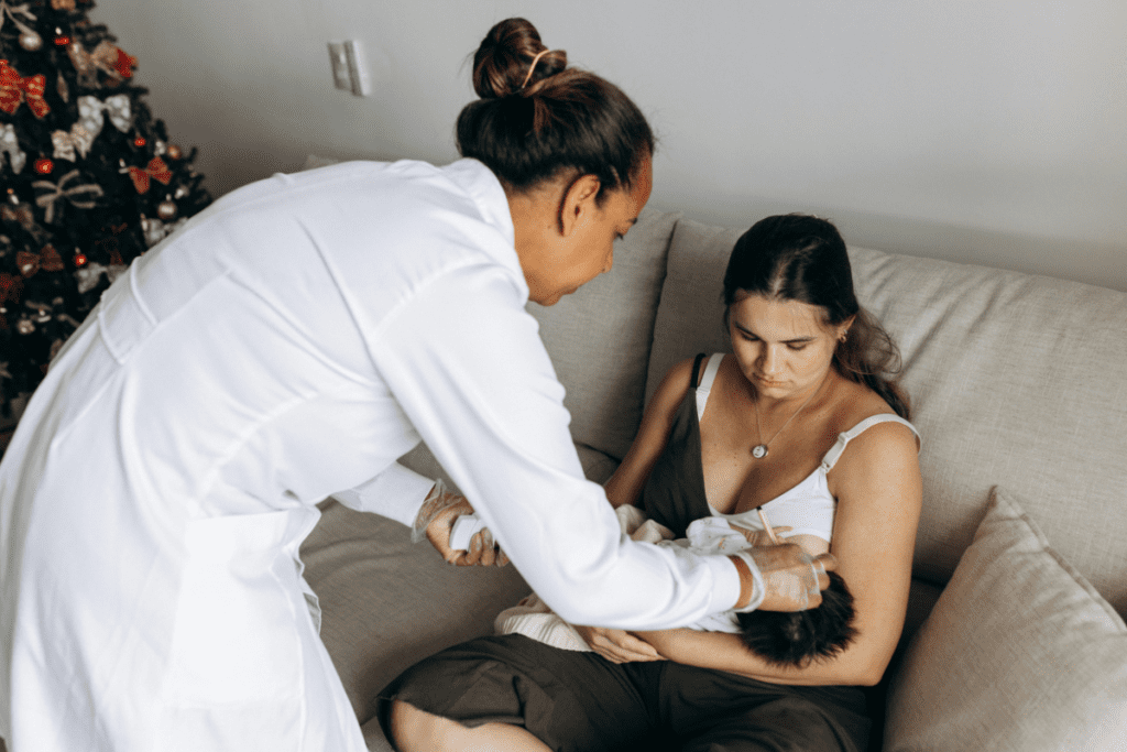 A supportive doula with a new mom, offering comfort and guidance during postpartum recovery.