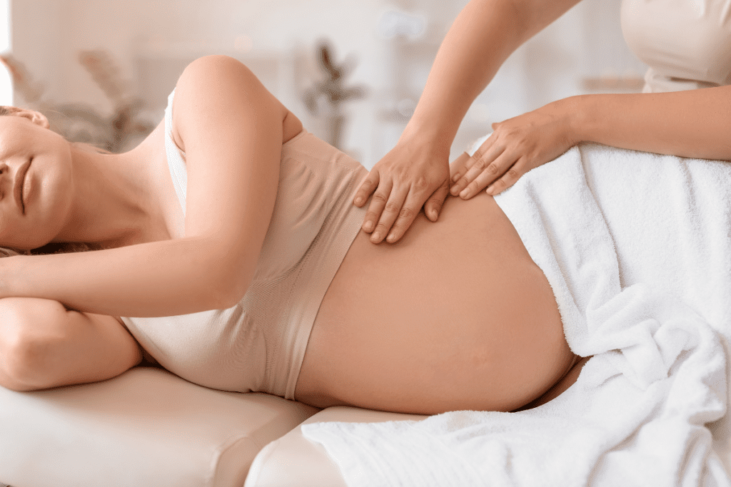 A pregnant woman receiving a gentle prenatal massage for relaxation and labor preparation.