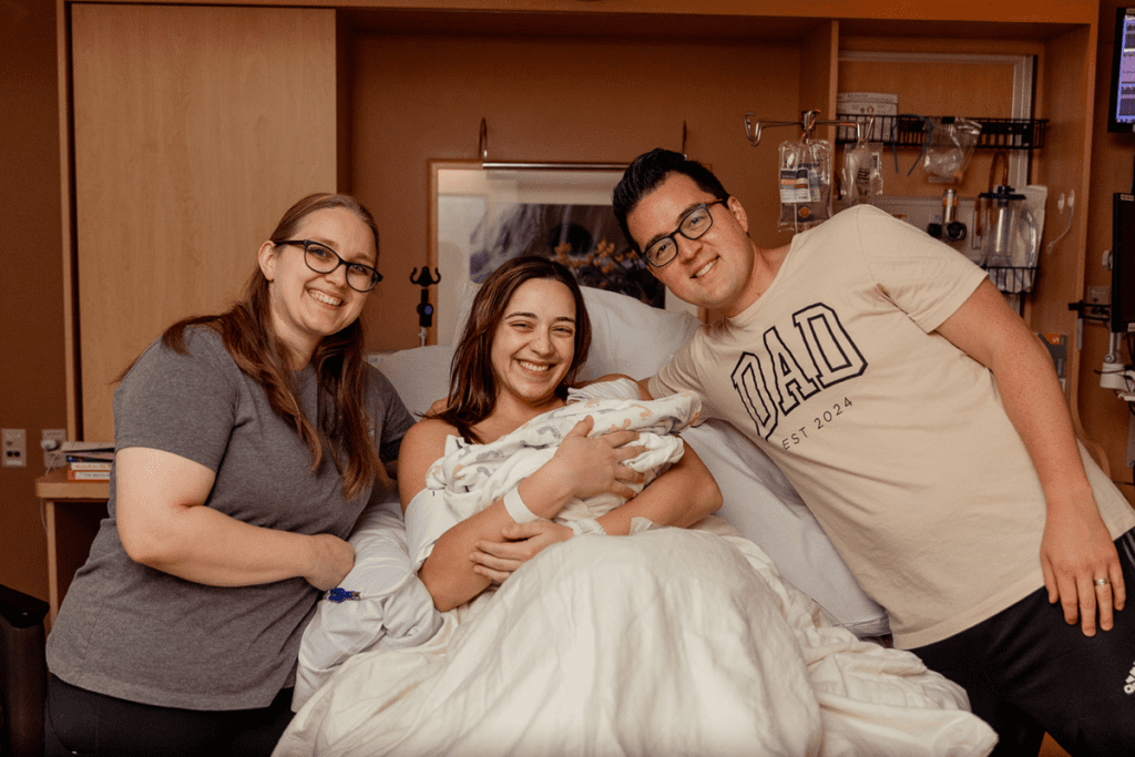 Joyful parents and newborn with baby nest doula assistance