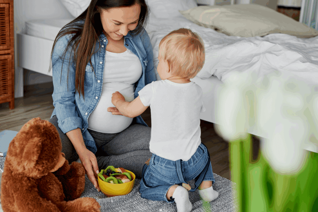a pregnant mom eating fruit with her toddler