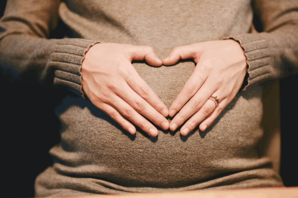 single mom using surrogacy in portland oregon, hands in heart shape on her belly